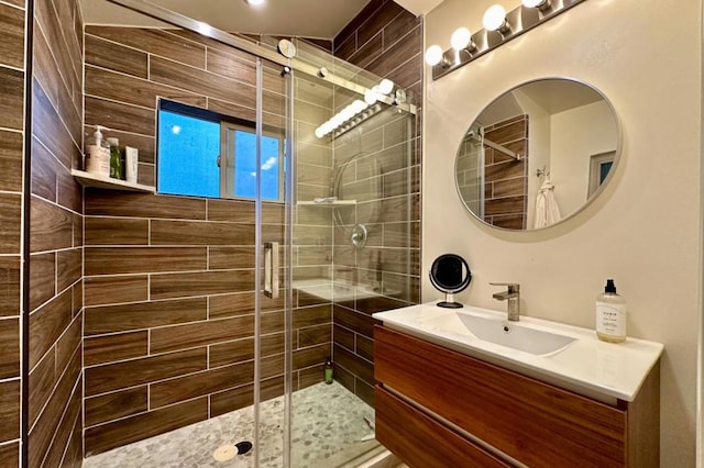 bathroom with a shower with door and vanity