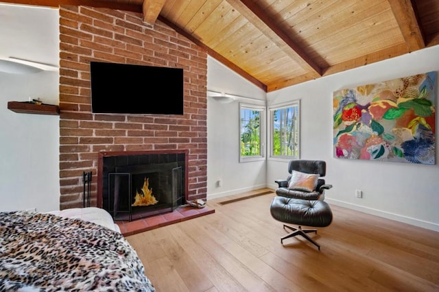 interior space featuring a brick fireplace, light hardwood / wood-style floors, lofted ceiling with beams, and wooden ceiling