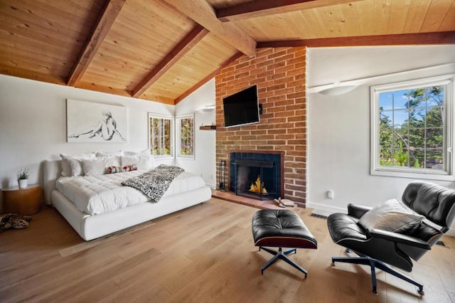 bedroom featuring light wood-type flooring, a brick fireplace, wooden ceiling, and lofted ceiling with beams