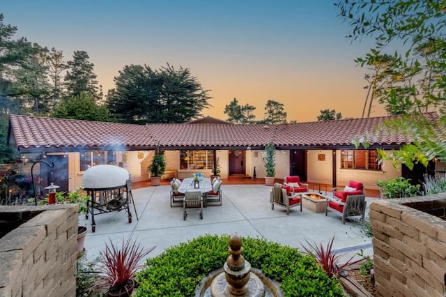 patio terrace at dusk featuring an outdoor living space with a fire pit