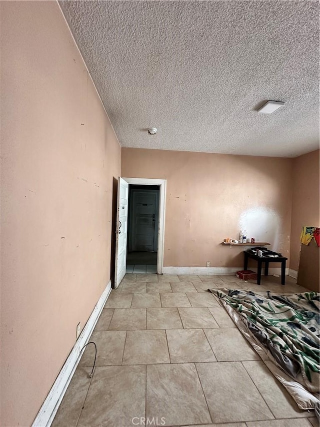 interior space featuring light tile patterned floors and a textured ceiling