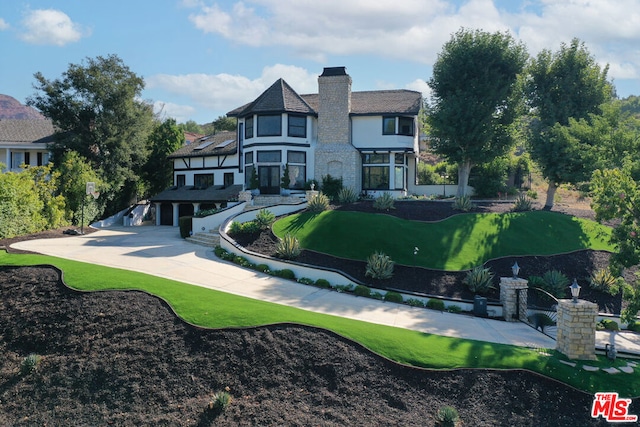 back of property with a garage and a lawn