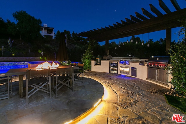 patio at twilight featuring wine cooler, area for grilling, and a pergola