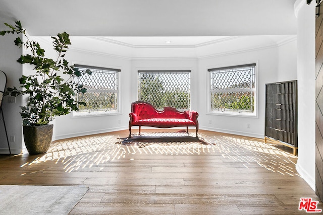 living area with ornamental molding and hardwood / wood-style flooring