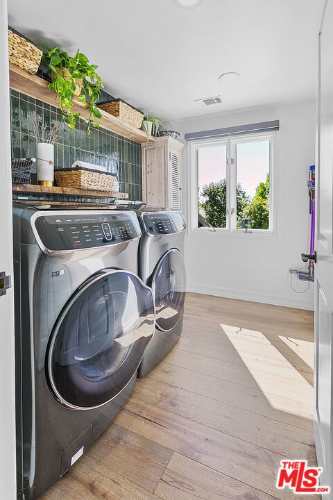 washroom with washer and clothes dryer and light hardwood / wood-style floors