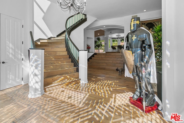 entryway featuring dark wood-type flooring and an inviting chandelier