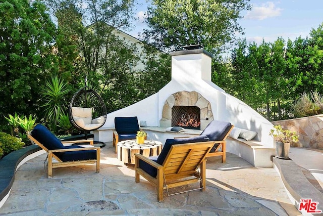 view of patio featuring an outdoor stone fireplace