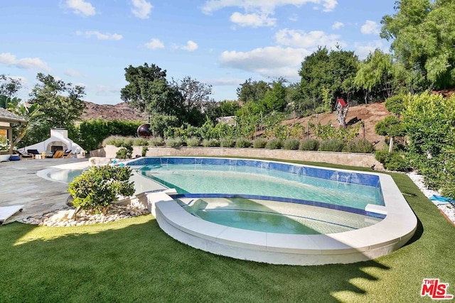 view of pool featuring an in ground hot tub and a lawn