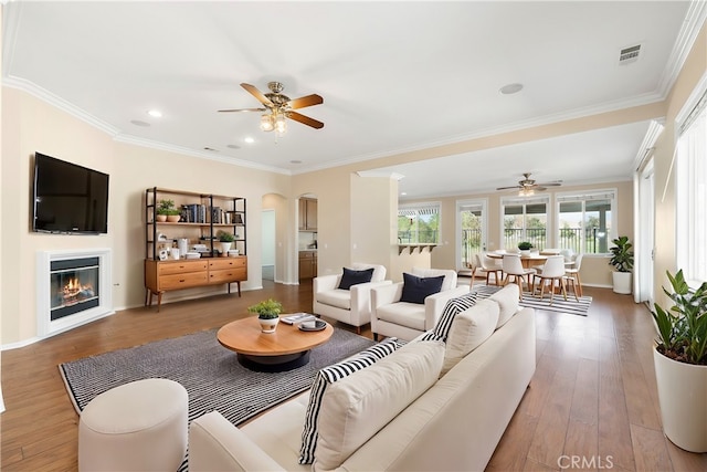 living room featuring ceiling fan, crown molding, and hardwood / wood-style floors