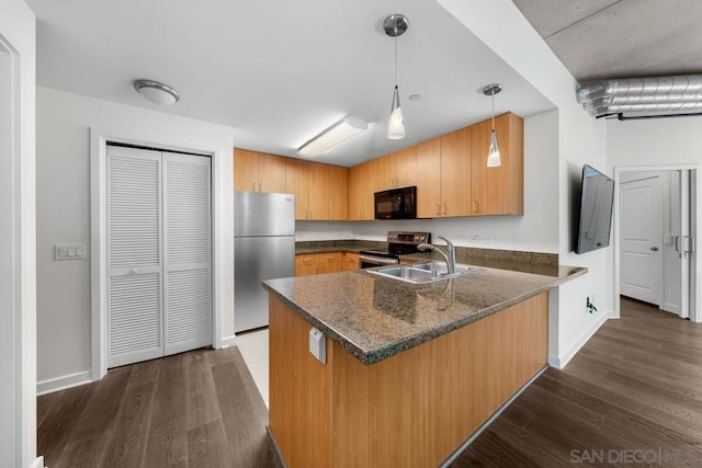 kitchen featuring hanging light fixtures, sink, kitchen peninsula, stainless steel appliances, and dark hardwood / wood-style floors