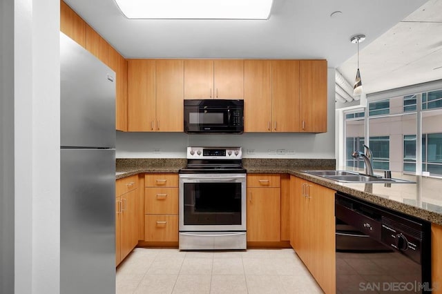 kitchen featuring pendant lighting, light tile patterned flooring, sink, black appliances, and dark stone countertops