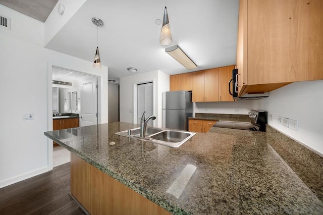 kitchen featuring dark hardwood / wood-style floors, sink, kitchen peninsula, black appliances, and decorative light fixtures