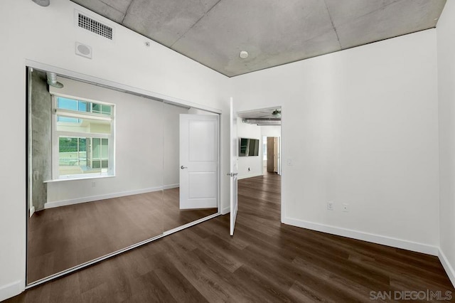 unfurnished bedroom featuring a closet and dark hardwood / wood-style flooring