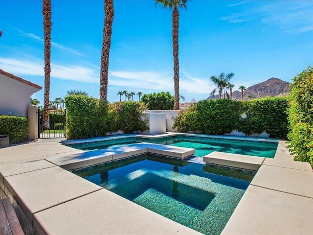 view of swimming pool with an in ground hot tub and a mountain view