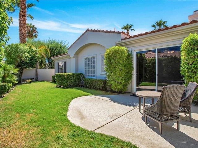 back of house featuring a lawn and a patio