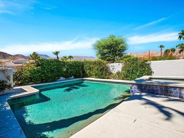 view of swimming pool featuring an in ground hot tub and a patio area