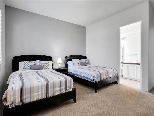 bedroom featuring light carpet and ensuite bath