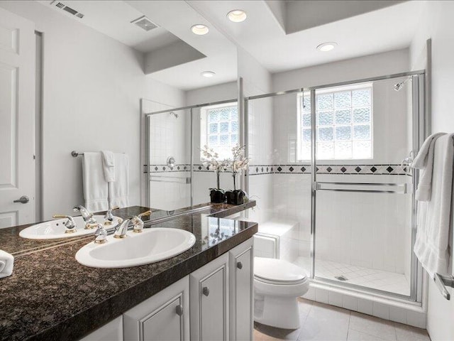 bathroom featuring toilet, vanity, tile patterned floors, and walk in shower