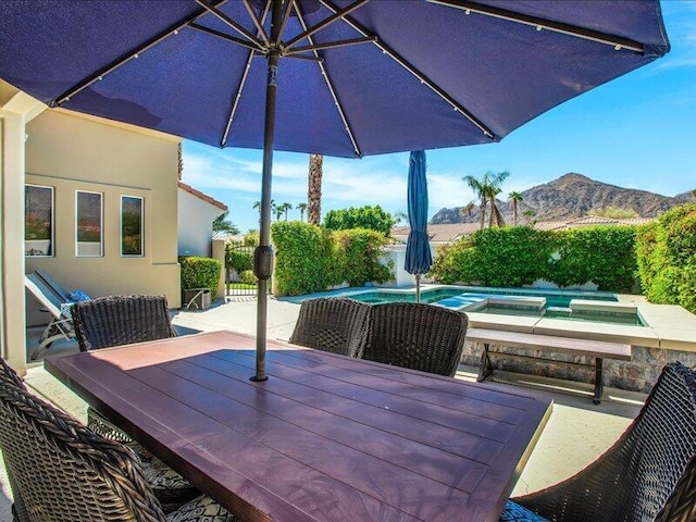 view of patio with an in ground hot tub and a mountain view