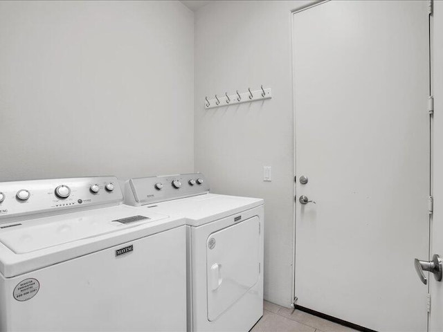 washroom with light tile patterned floors and washer and dryer