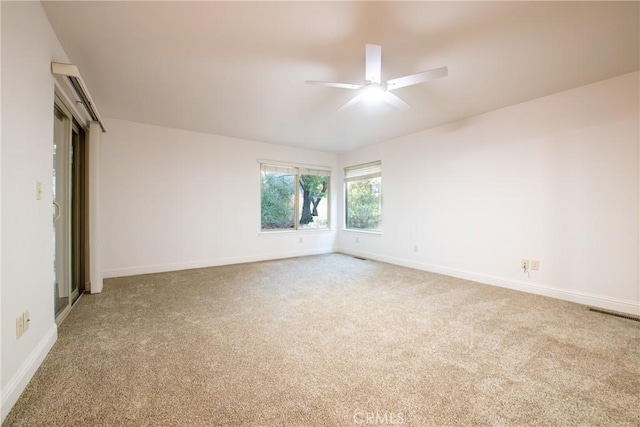 carpeted spare room with ceiling fan