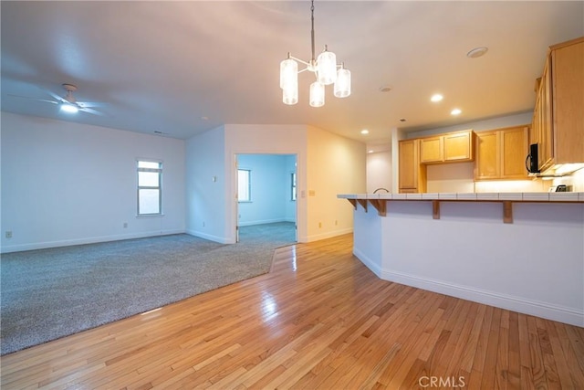 10 Hidden Brooke Way, Chico, CA 95928 - kitchen with tile countertops, a chandelier, a kitchen bar, light wood-style flooring, and open floor plan