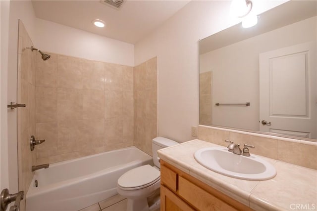 full bathroom featuring tile patterned flooring, vanity, toilet, and tiled shower / bath