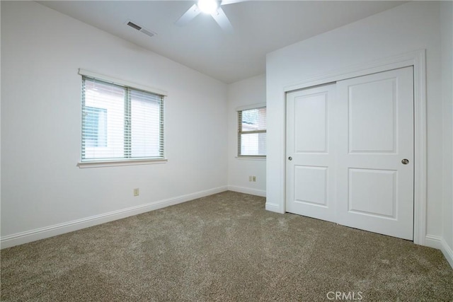 unfurnished bedroom with carpet, ceiling fan, and multiple windows