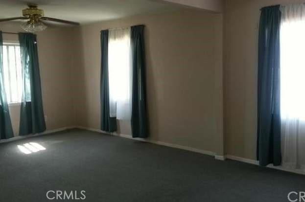 unfurnished room with carpet floors and ceiling fan