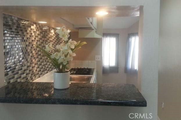 kitchen with dark stone counters and tasteful backsplash