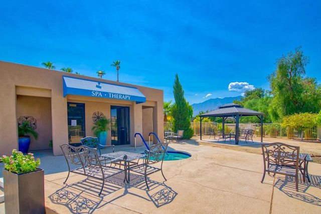 view of patio / terrace featuring a gazebo, a mountain view, and a swimming pool