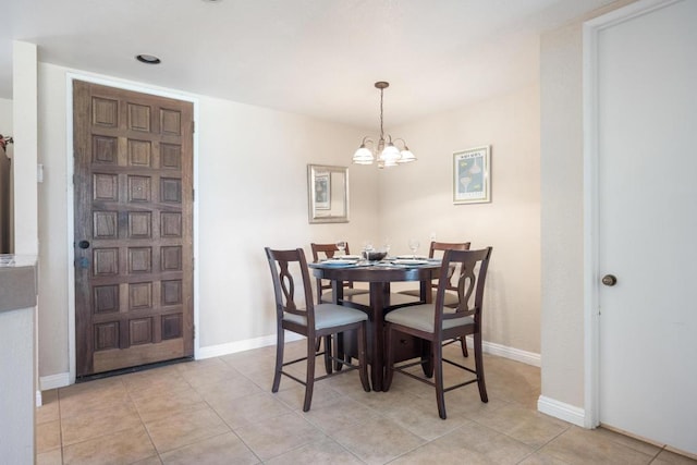 tiled dining area featuring a chandelier