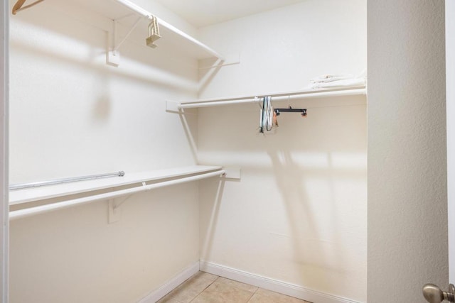 walk in closet with light tile patterned floors