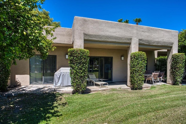 rear view of house featuring a lawn and a patio