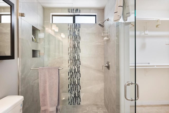 bathroom featuring toilet, tile patterned flooring, and walk in shower