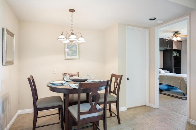 tiled dining area with ceiling fan with notable chandelier