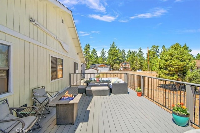 deck featuring an outdoor living space with a fire pit