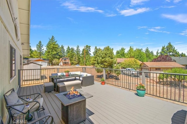 deck with an outdoor living space with a fire pit and a storage shed