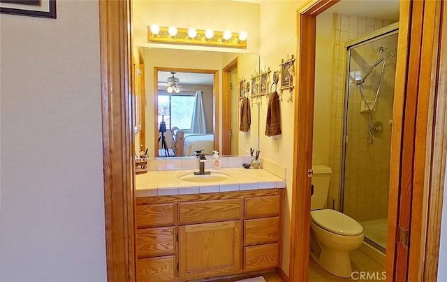 bathroom featuring toilet, walk in shower, and vanity