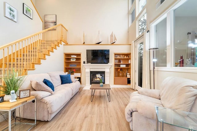 living room with a towering ceiling and hardwood / wood-style floors