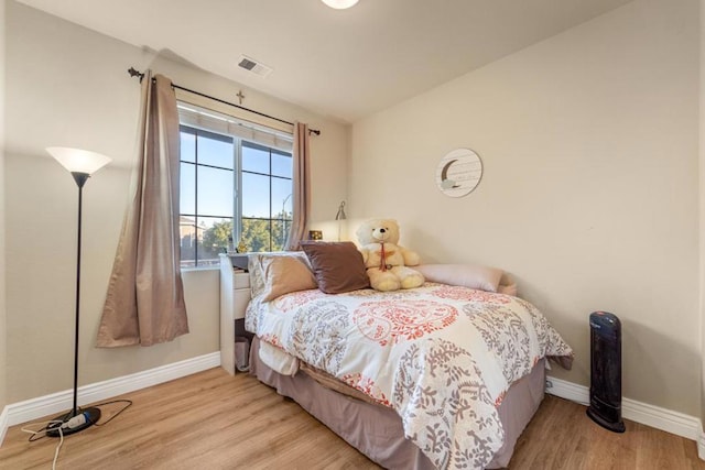 bedroom with light hardwood / wood-style flooring and lofted ceiling