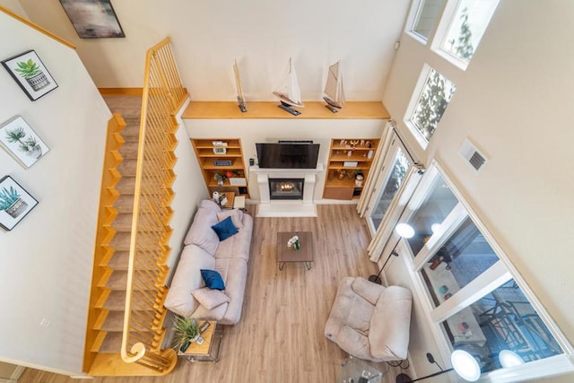 living room with light wood-type flooring and a high ceiling