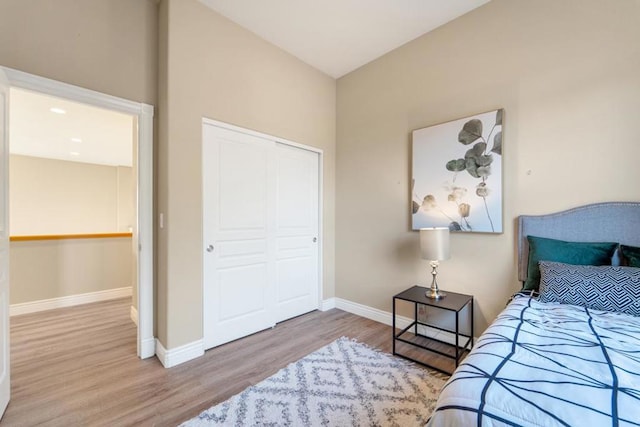 bedroom with light hardwood / wood-style flooring and a closet