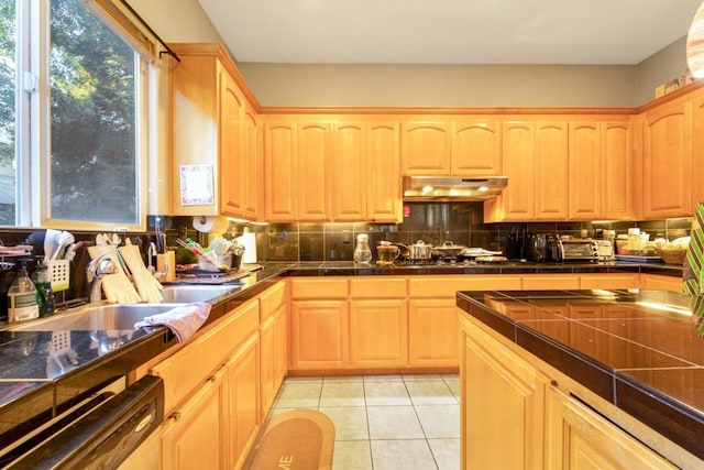 kitchen featuring light brown cabinets, light tile patterned flooring, stainless steel appliances, and decorative backsplash