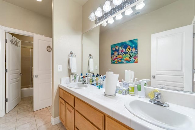 bathroom with tile patterned floors, shower / bath combination with glass door, and vanity