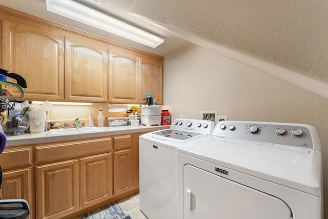 laundry area with sink, independent washer and dryer, and cabinets