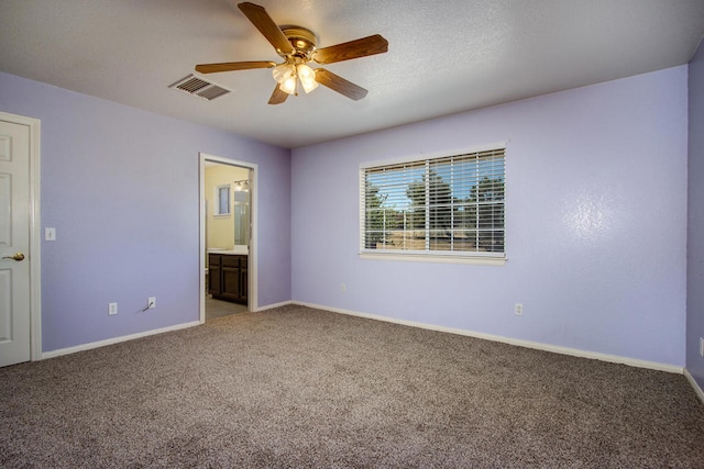 unfurnished bedroom with ceiling fan, carpet, and ensuite bath