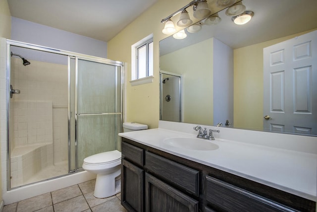 bathroom featuring tile patterned flooring, vanity, walk in shower, and toilet