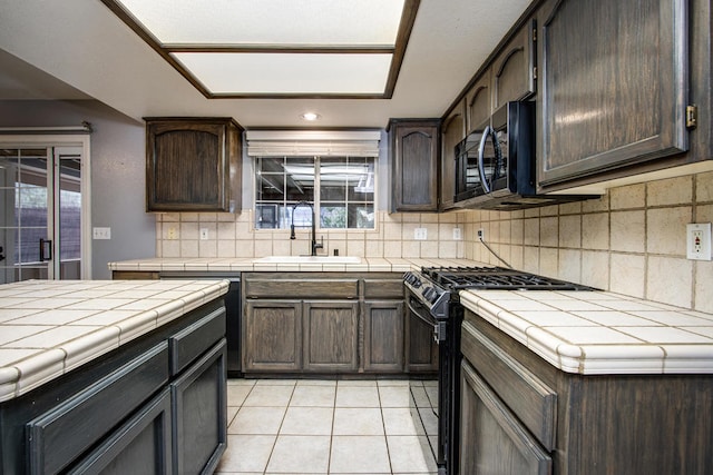 kitchen with sink, tasteful backsplash, range with gas cooktop, and tile countertops