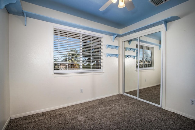 unfurnished bedroom with ceiling fan, a closet, and carpet flooring